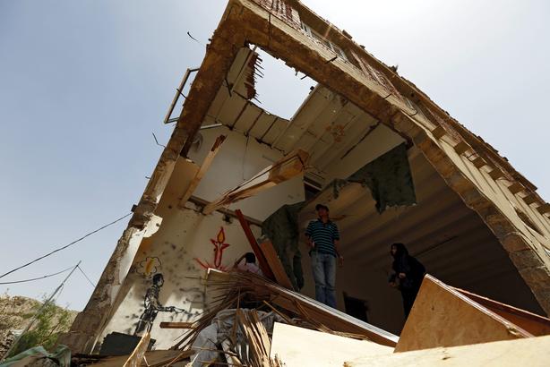 2015-06-13 10:49:18 epa04797445 Yemeni artists spray graffiti on an inner wall of an airstrike-destroyed building to commemorate the victims of an airstrike of the Saudi-led coalition, in Sana'a, Yemen, 13 June 2015. According to UN estimates, at least 2,200 people have been killed and more than 10,000 others injured in Yemen since the Saudi-led coalition launched airstrikes in late March against the Houthi rebels and their allies who forced Yemeni President Abdo Rabbo Mansour Hadi out of the country.  EPA/YAHYA ARHAB
