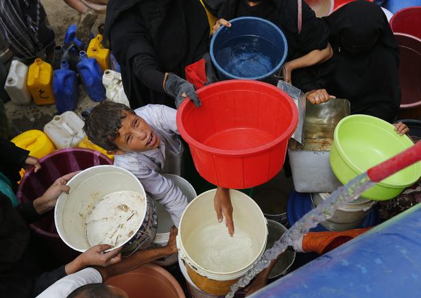 2015-07-04 13:49:25 epa04831554 Yemenis fill buckets with water from a donated source amid disruption of water supplies, in Sanaa, Yemen, 04 July 2015. Many Yemenis are suffering from a lack of basic services and resources, in a humanitarian disaster dramatically worsened by a blockade imposed by the Saudi-led coalition targeting the Houthi rebels' and allied positions in the impoverished Arab state.  EPA/YAHYA ARHAB